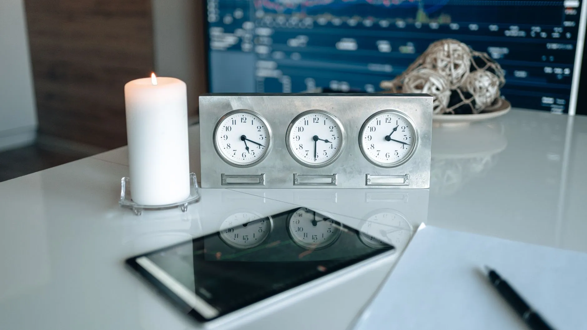 Desk with world clocks and a tablet, tracking time zones when you outsource SEO