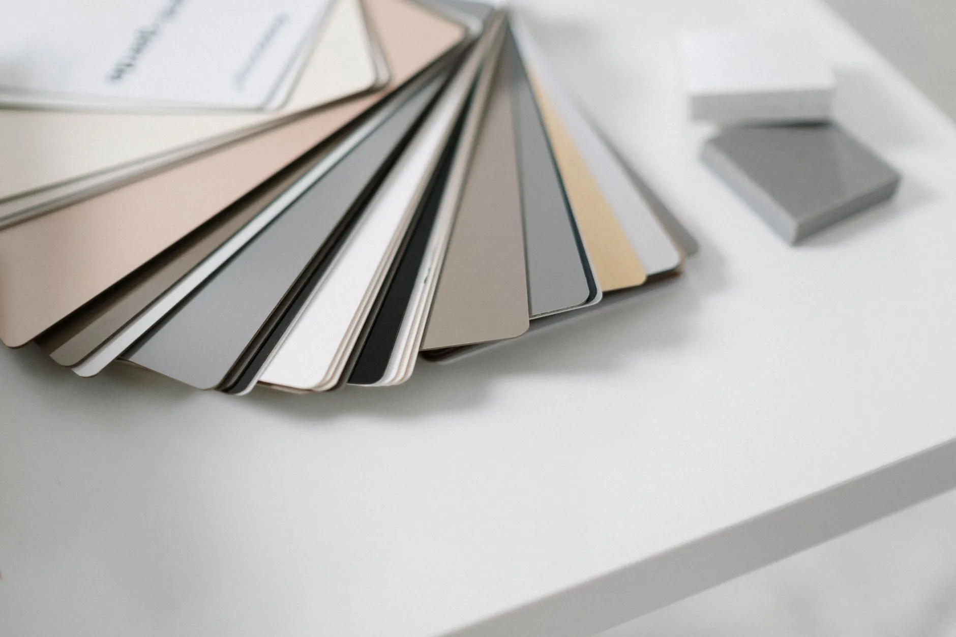 Neutral color samples laid out on a white desk while a branding agency chooses a palette