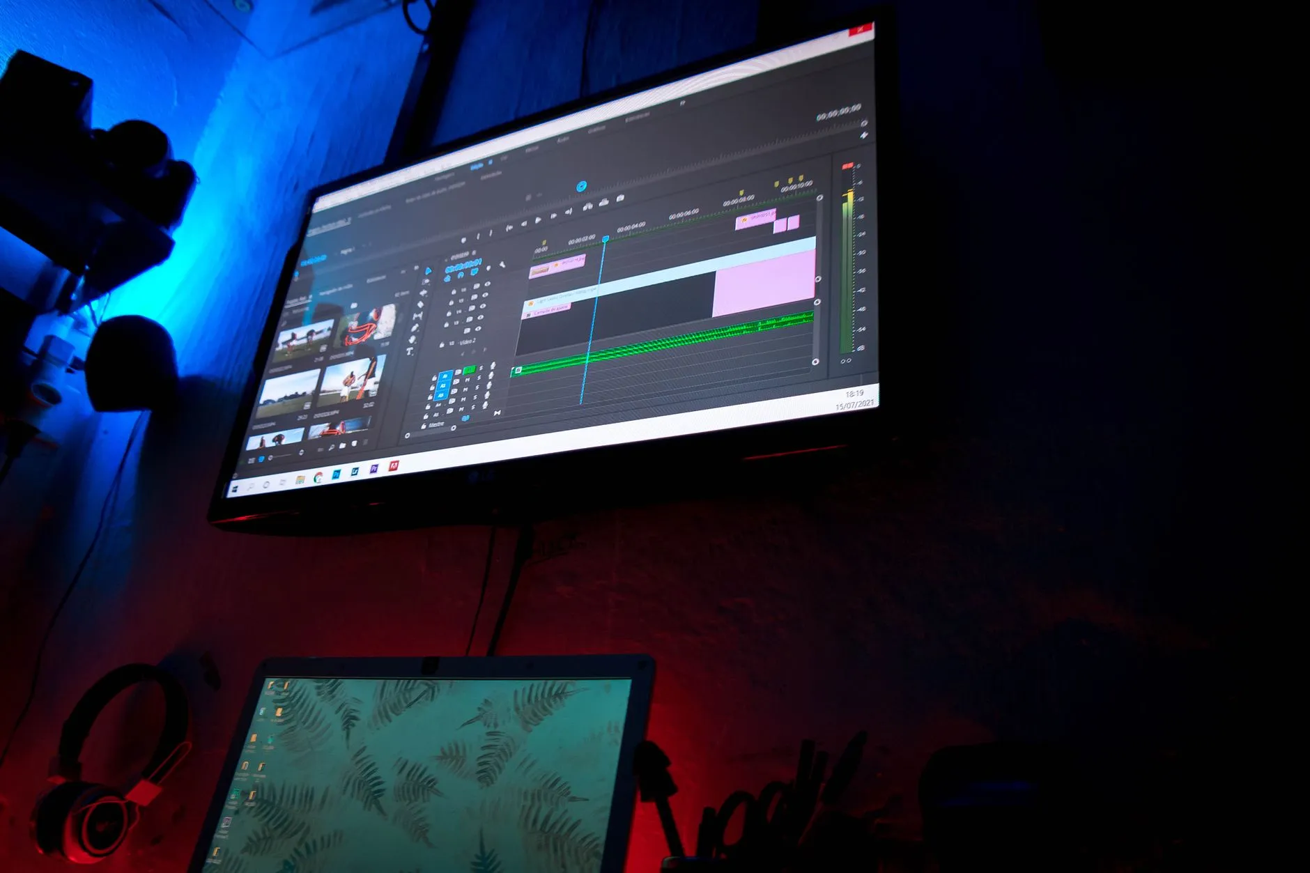 Dark editing room with screens showing video editing software during video production