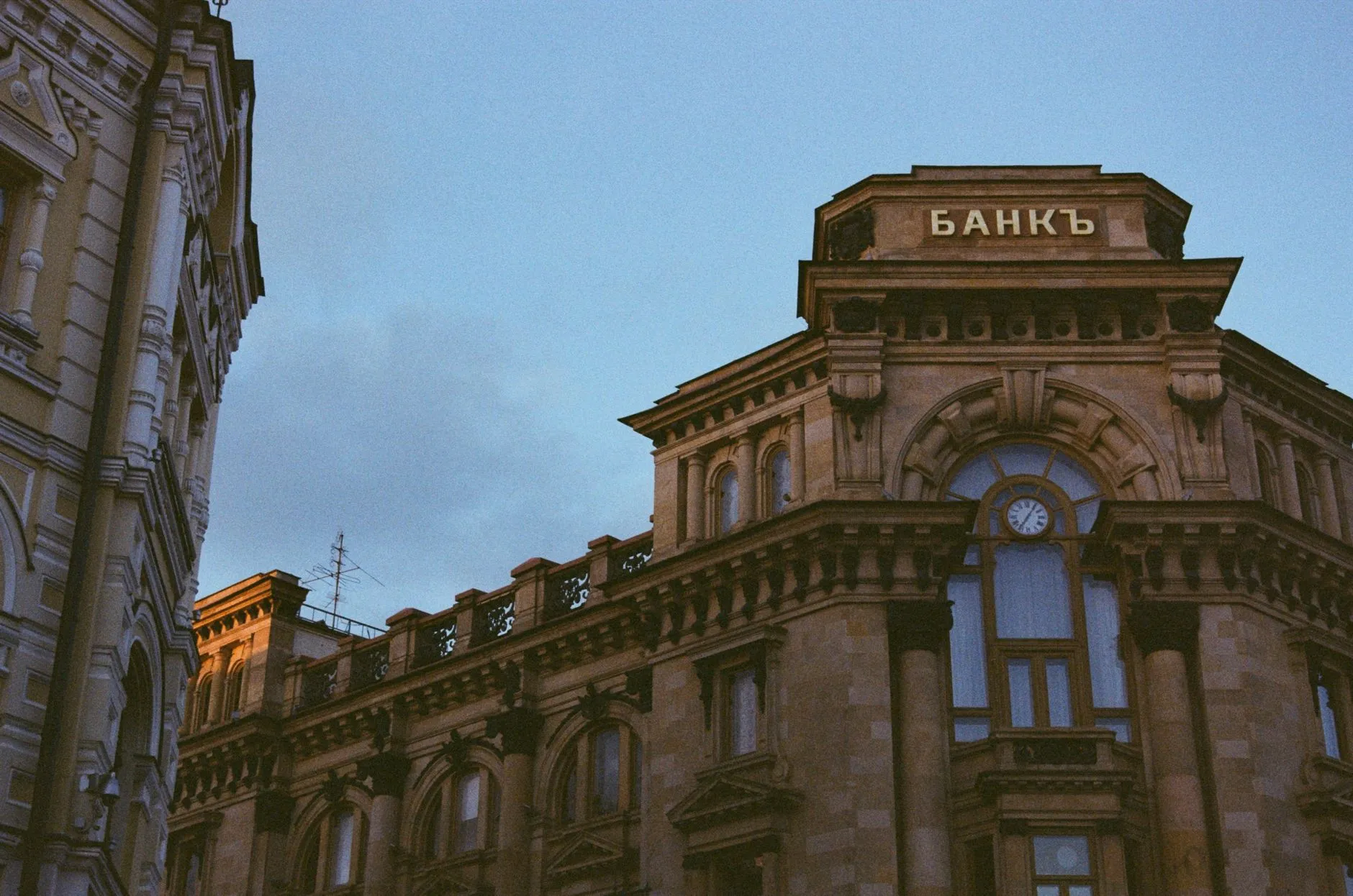 Classic bank building facade with stone columns under a blue sky